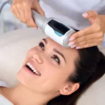 Cosmetic specialist performing facial treatment with Endospheres device on smiling woman